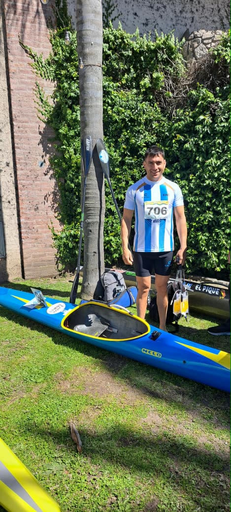 Deportista de la Escuela Municipal de Canotaje de Patagones junto a su kayak