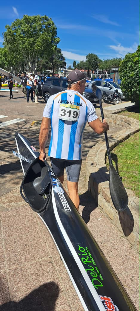 Palista de la selección argentina trasladando su kayak hacia la zona de competencia