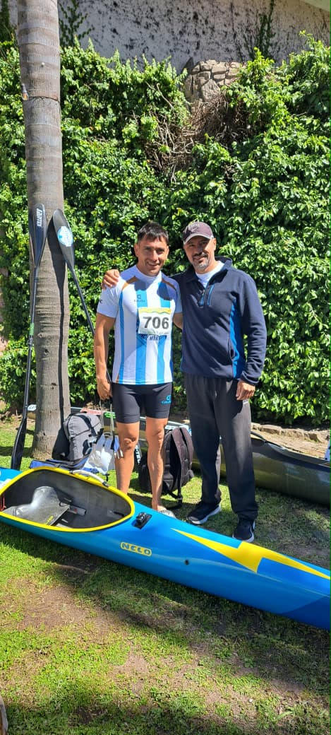 Palista de Patagones junto a un integrante del cuerpo técnico en el Mundial de Canotaje Maratón