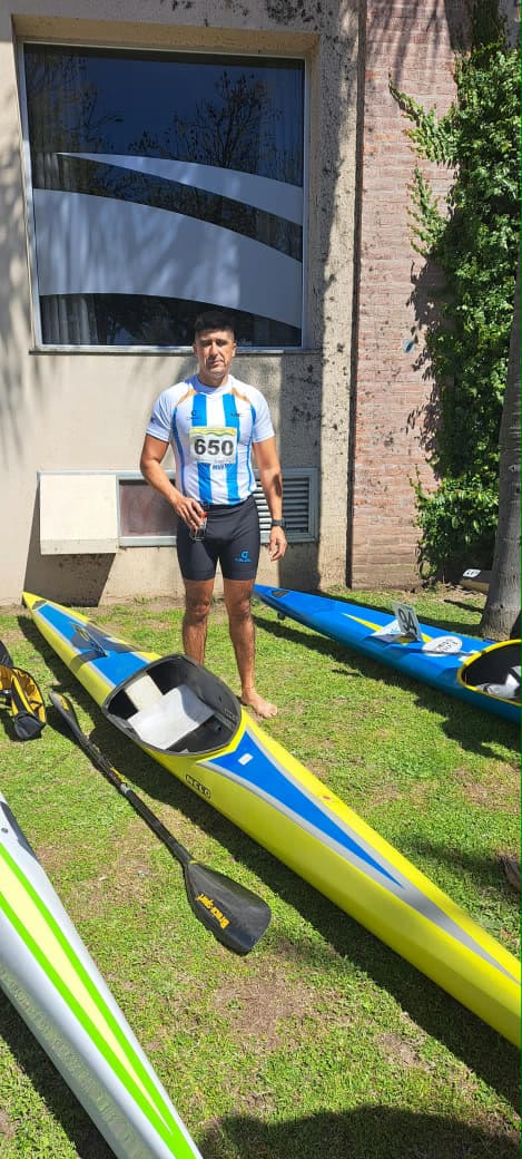 Palista de Patagones con la remera argentina y su kayak en el Mundial de Canotaje Maratón